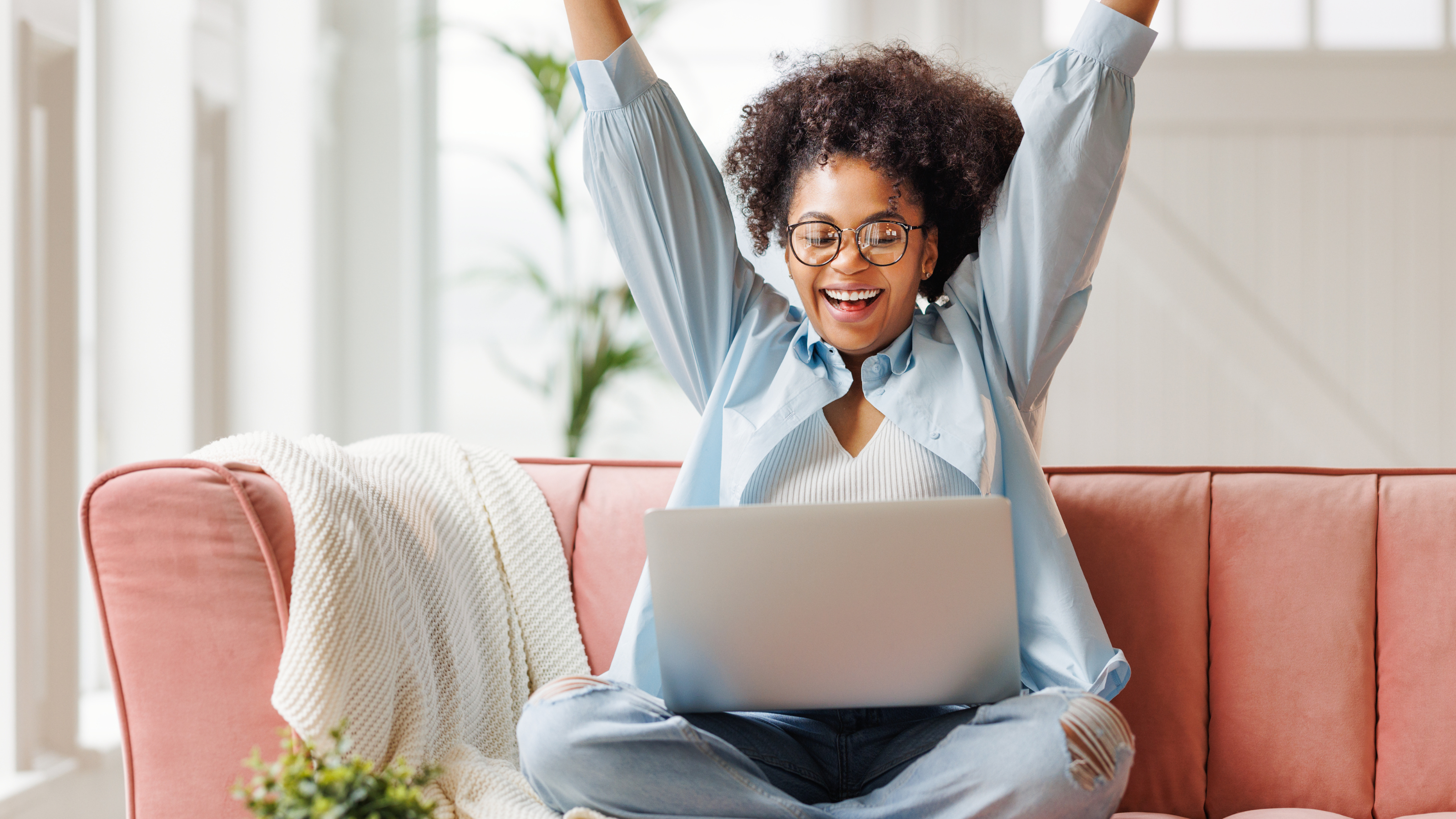 A woman with arms in the air following webinar success