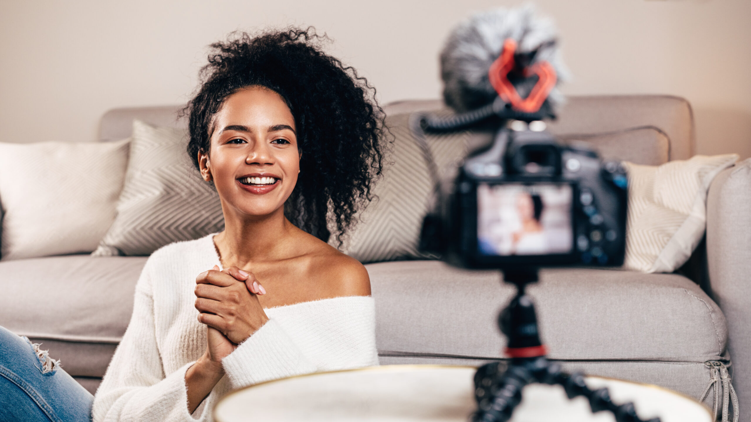 African American woman live streaming from living room to build an audience online.